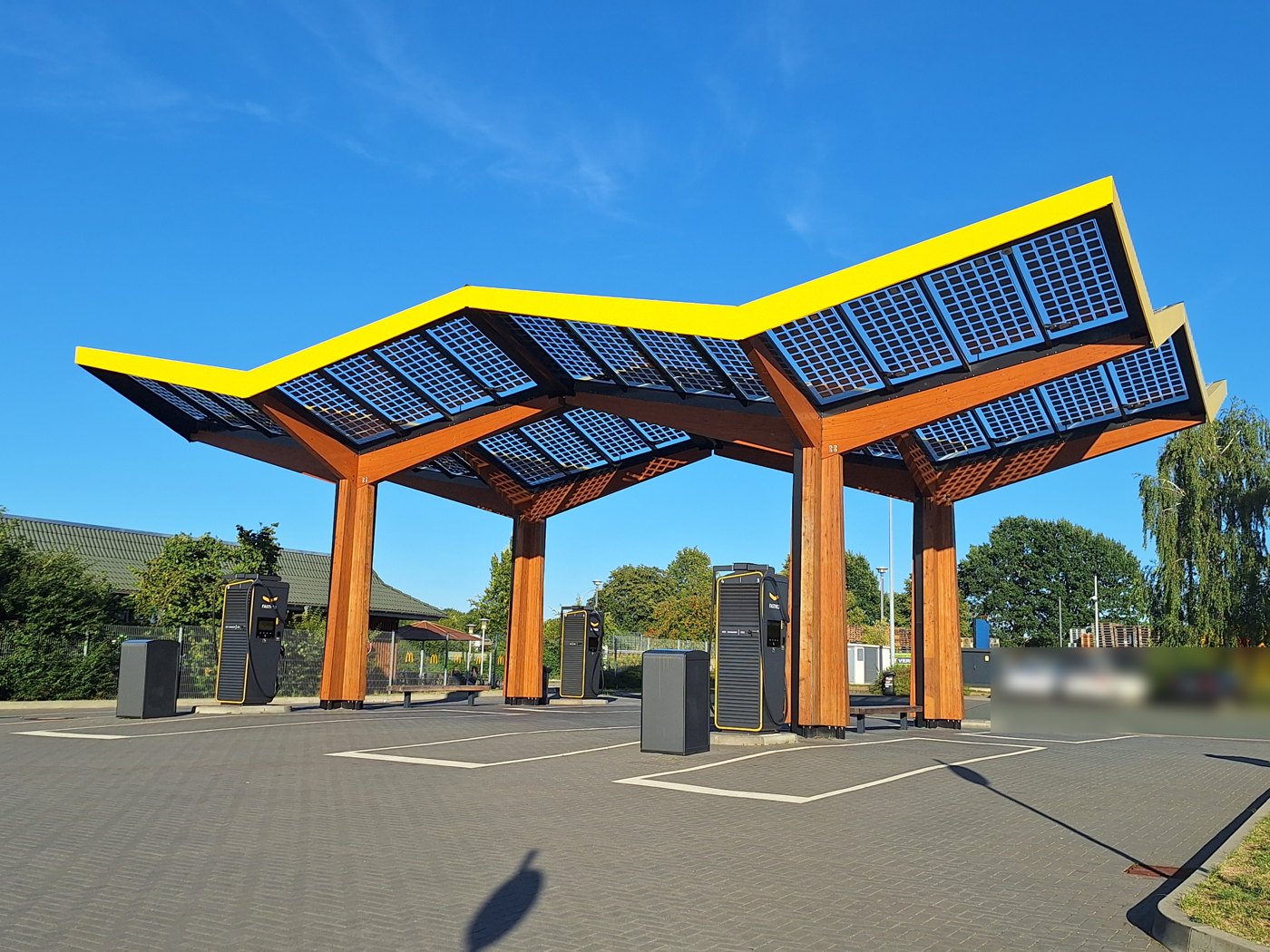 지붕 아래 충전기가 설치되어 있고 측면이 열린 독일 Fastned 충전소